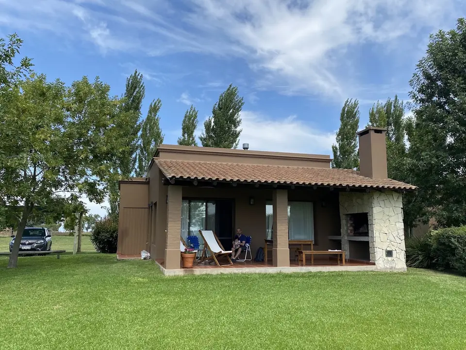 Una de las casas con su galería de tejas y la parrilla de piedra.