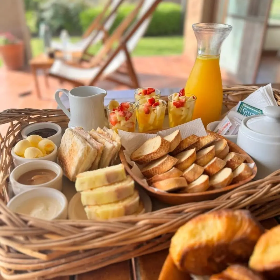 La canasta del desayuno en la galería: medialunas, tostadas, budín, frutas, jugo de naranja y termo.
