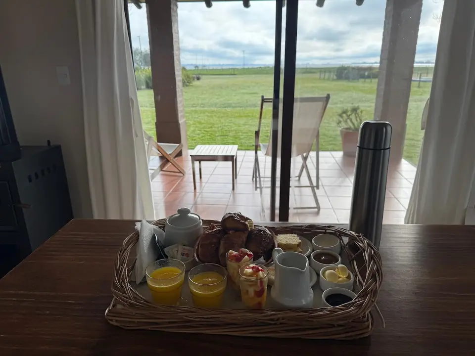 La canasta del desayuno sobre la mesa de la galería, con el campo atrás.