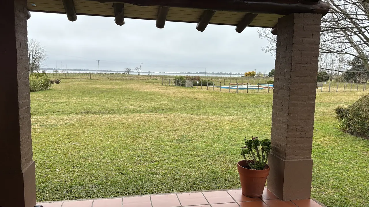 La vista desde la galería: el parque, la pileta y la laguna en el horizonte.