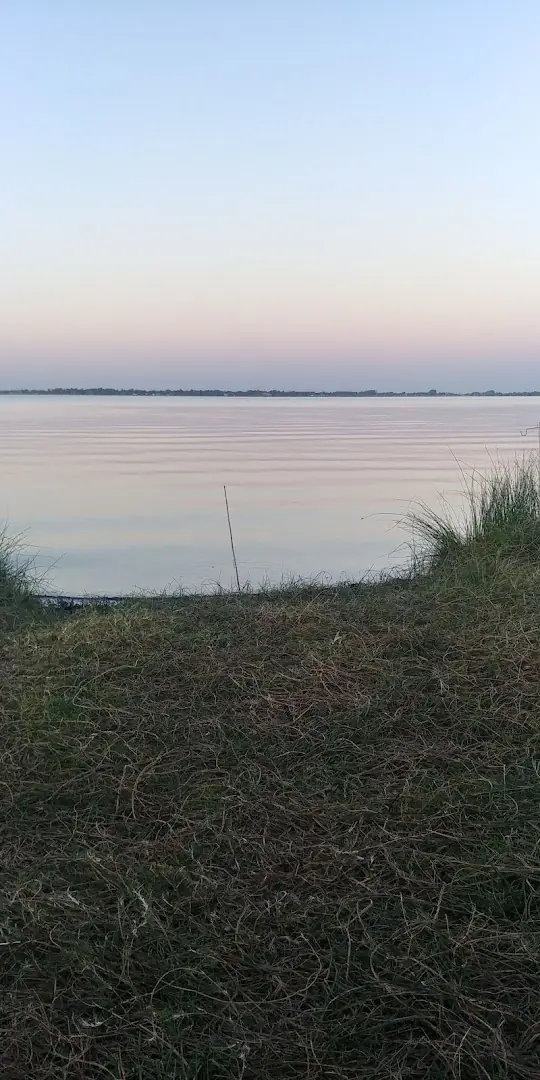 La laguna al atardecer, con el cielo rosado.