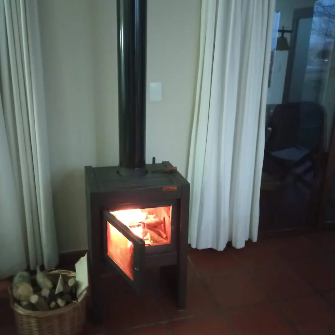 El living con la salamandra encendida y el ventanal a la galería.