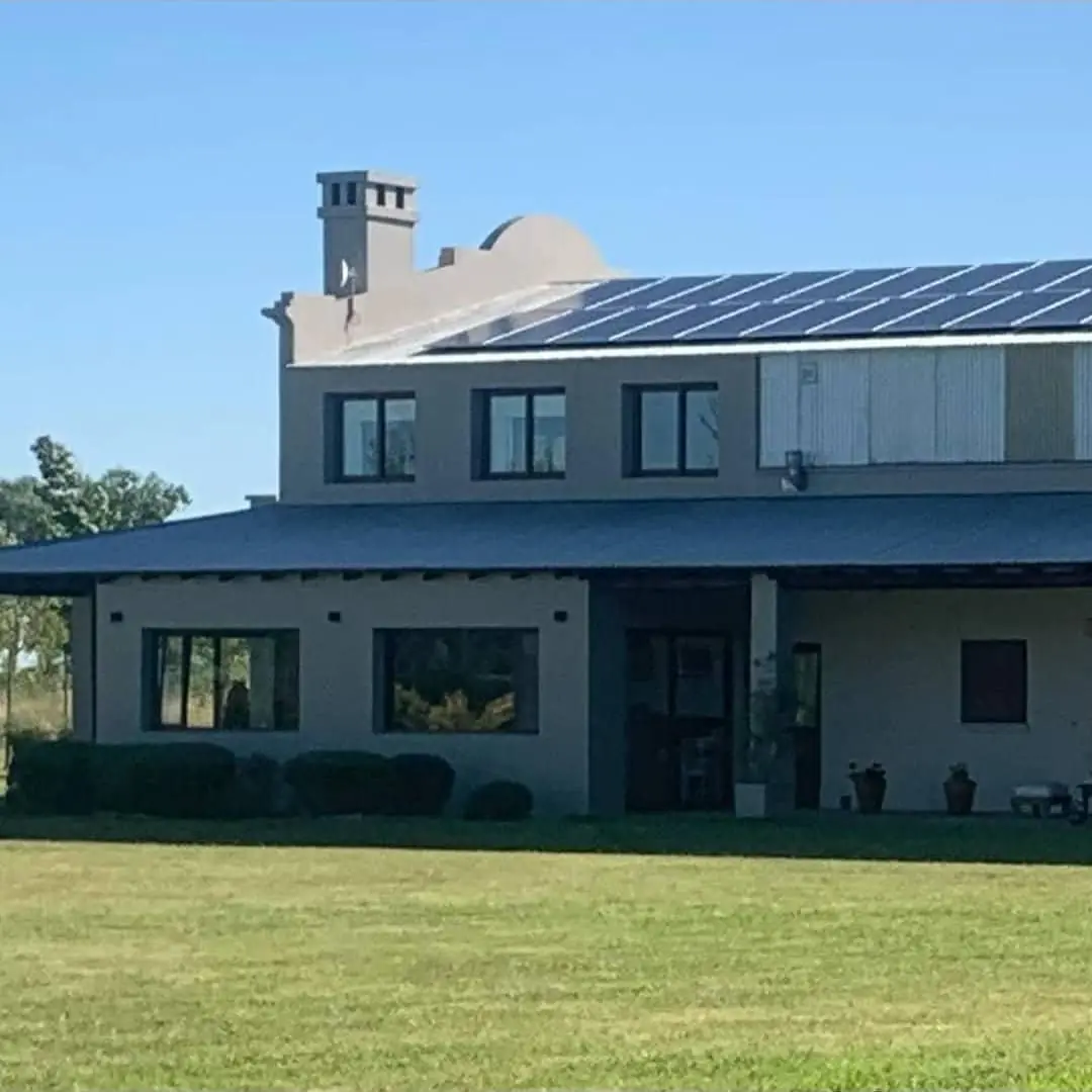 La casa de los dueños con los paneles solares sobre el techo.