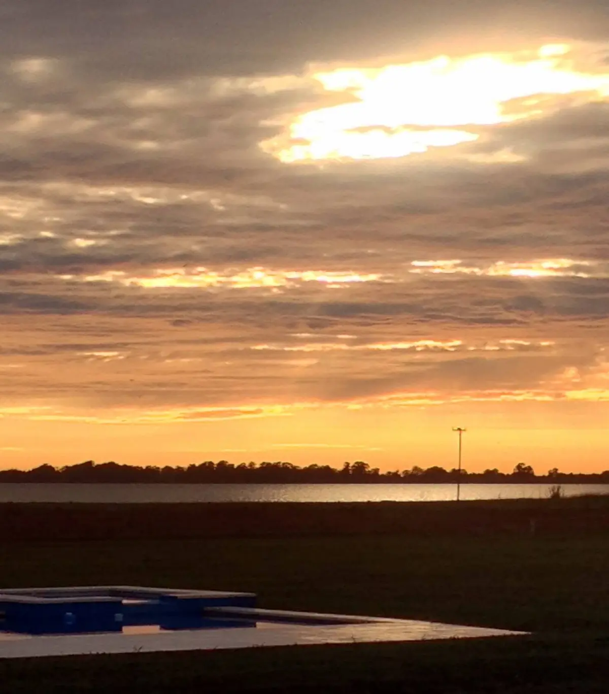 El atardecer sobre la laguna, desde la pileta.